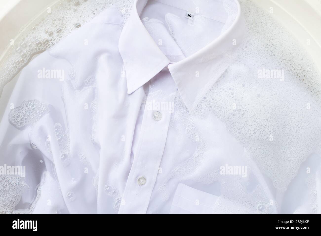 Empapar un paño antes de lavar, camisa blanca Fotografía de stock - Alamy