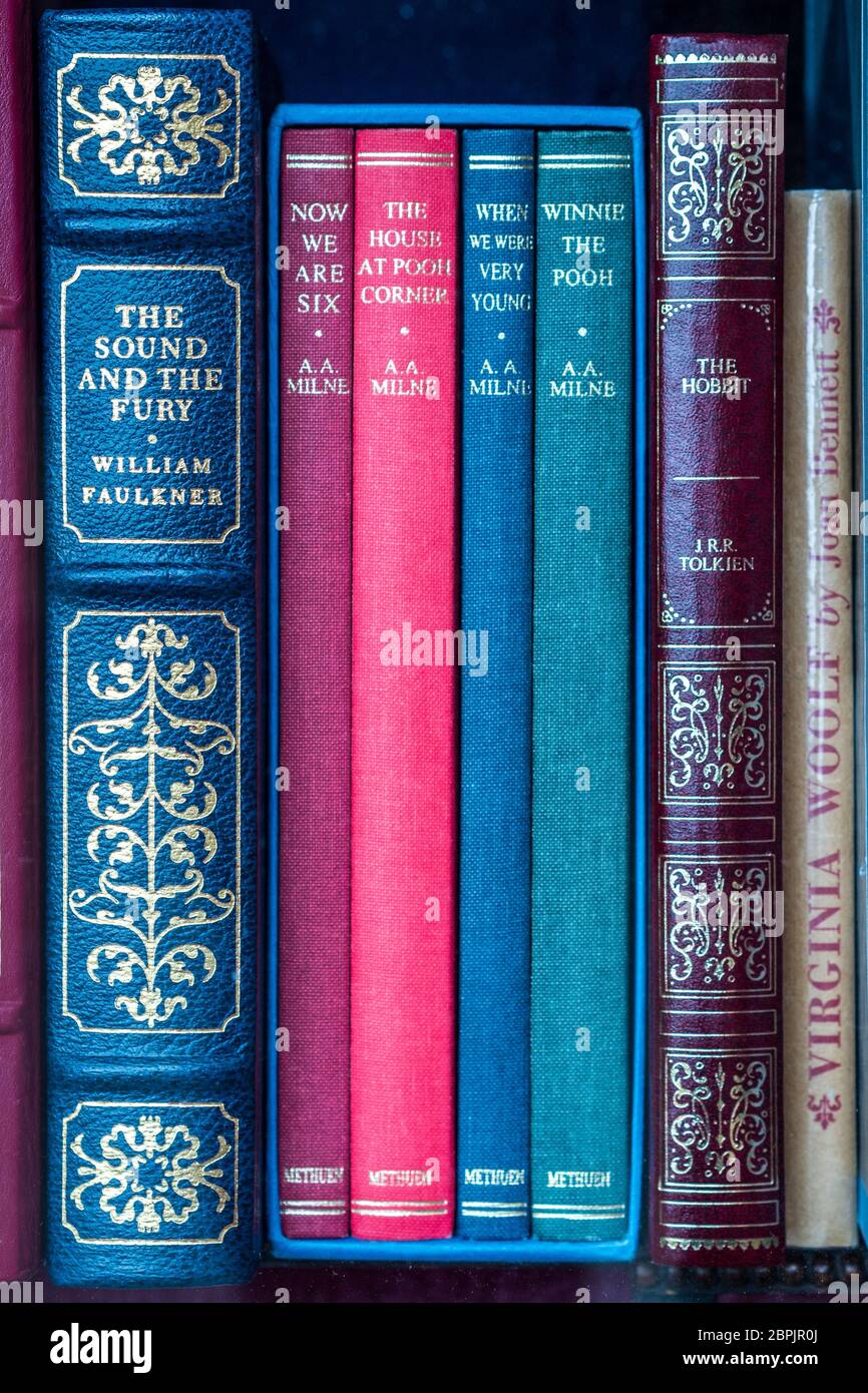 Colección de libros Winnie-the-Pooh, Methuen Collectors Edition 1999, por A. A. Milne junto al Hobbit y el sonido y la furia en una ventana de librería. Foto de stock