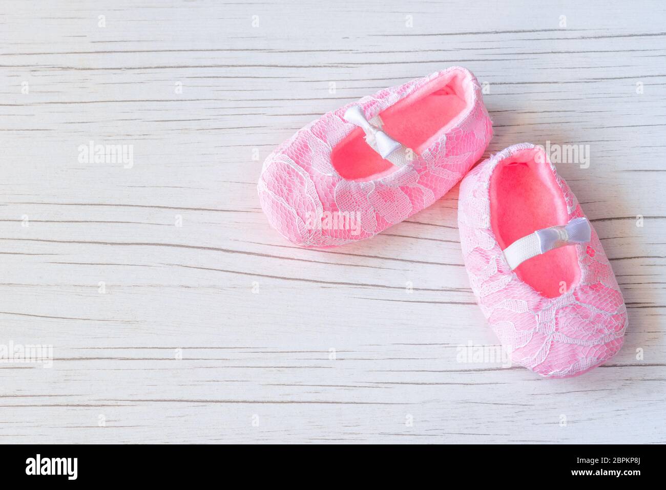 Zapatos de color rosa sobre fondo de madera blanca. Bebé esperando, bebé  ducha. Rosa niña recién nacido zapatos. Moda y ropa para el concepto de  bebé Fotografía de stock - Alamy