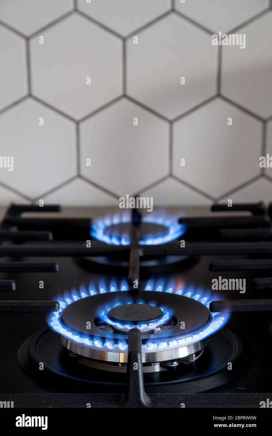 Llama azul de la estufa de gas de la cocina en el marco de hierro fundido  negro de la cocina cerca de los detalles de primer plano