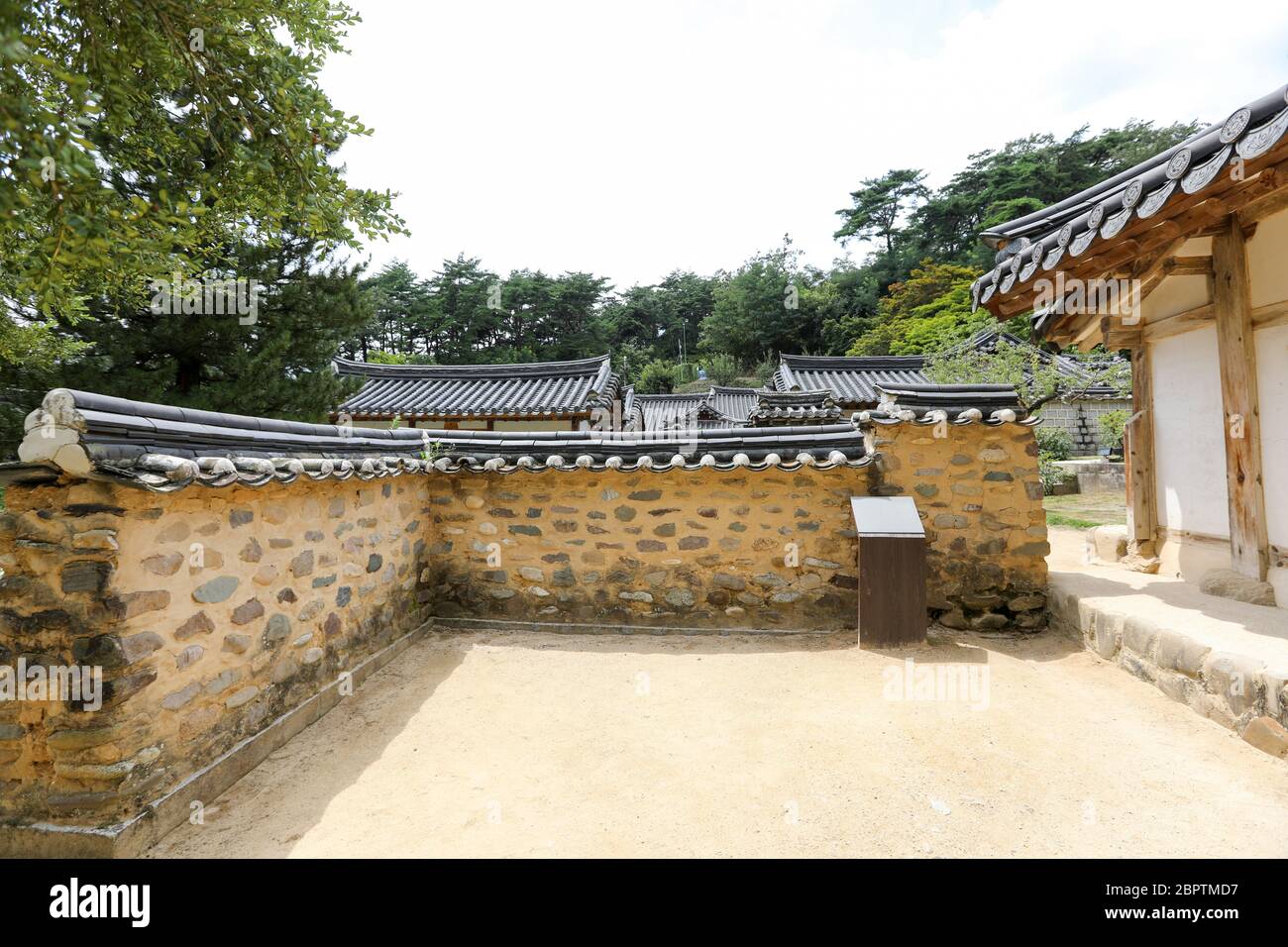 Tradicional techo de la casa coreana detrás de la pared de piedra. Foto de stock