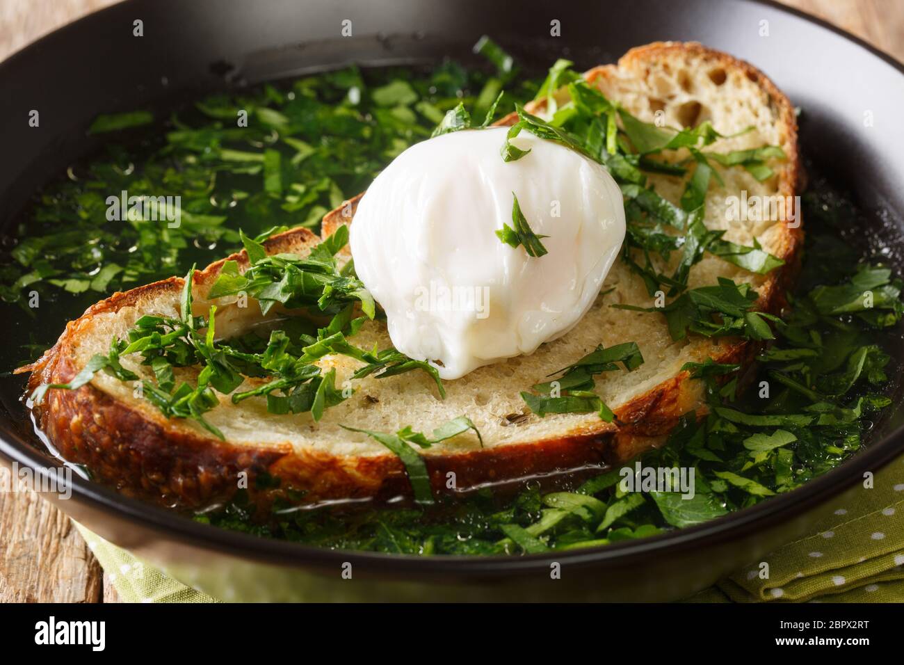 Receta para esta sopa de pan de garlicky acorda con huevo escalfado primer plano en un plato sobre la mesa. Horizontal Foto de stock