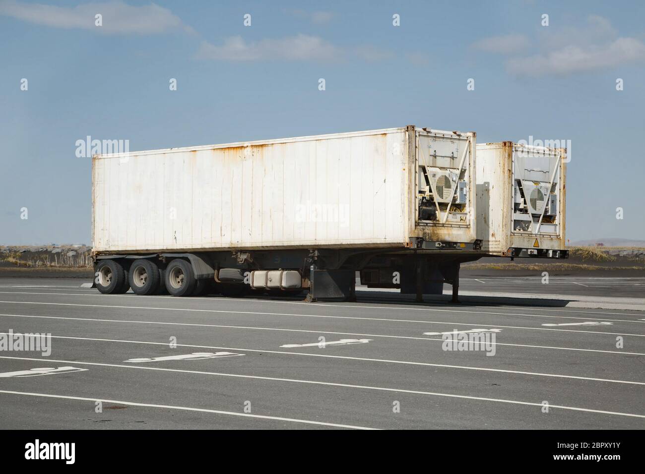 Contenedores de carga en remolques de camiones en un estacionamiento en Islandia Foto de stock