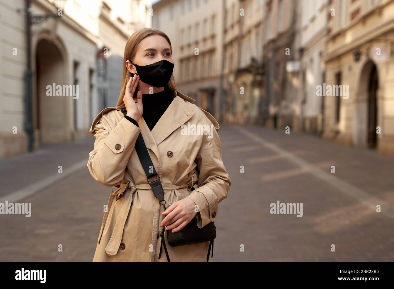 Mujer que lleva ropa de moda de moda durante la cuarentena de un brote de  coronavirus. Modelo de protección elegante máscara de cara hecha a mano.  Walkin turista Fotografía de stock -