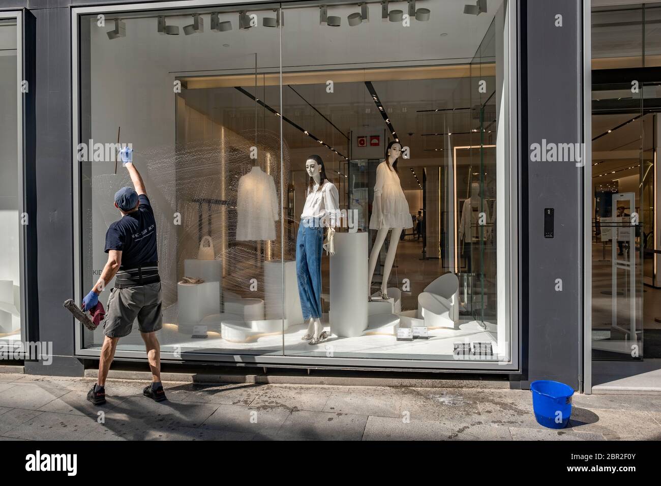 Un hombre del servicio de limpieza privada Zara / Inditex es visto limpiar  una ventana de la tienda la pequeña y mediana empresa minorista en Barcelona  se prepara para gestionar las ventas