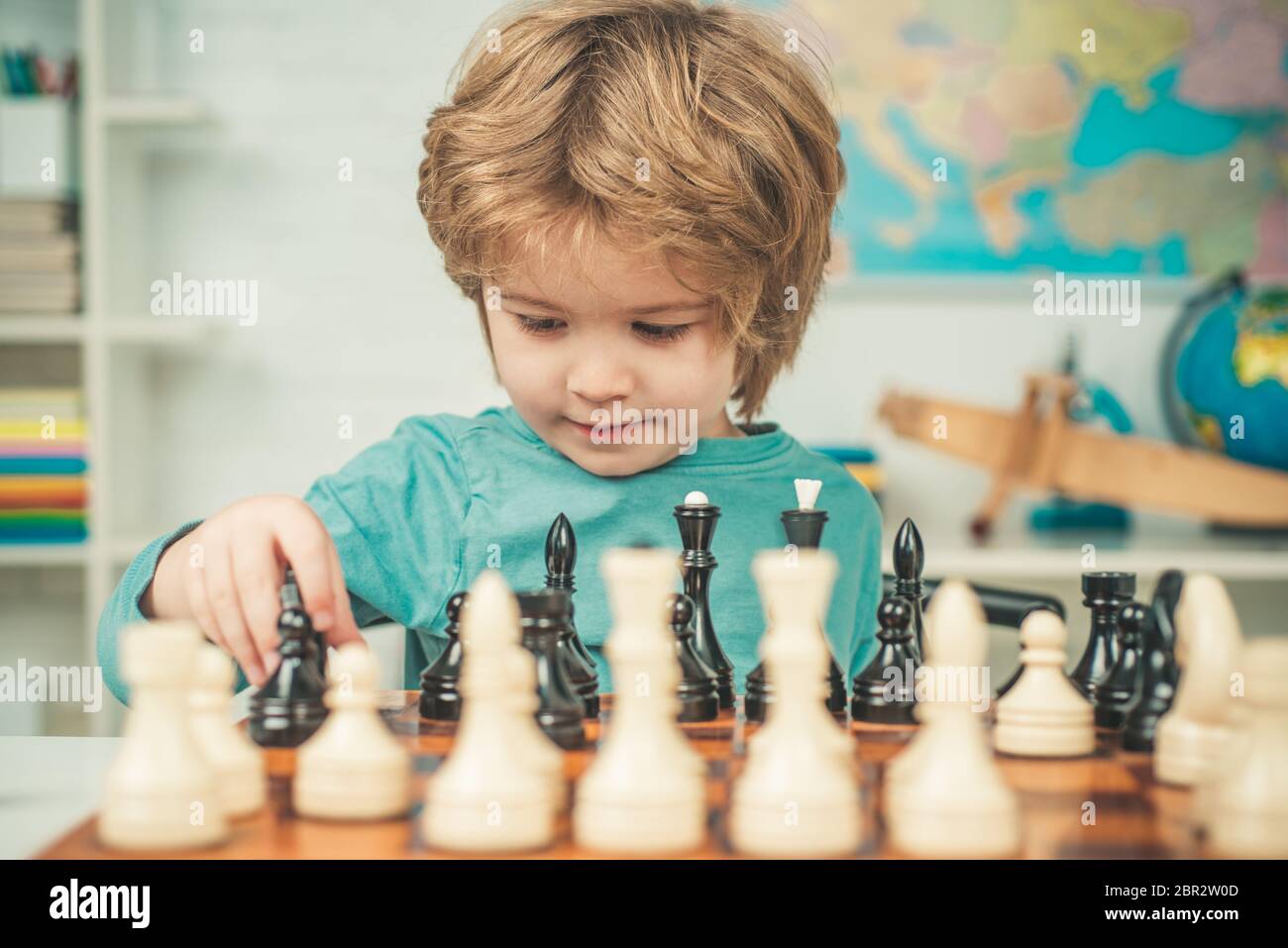 Niño inteligente concentrado y pensante mientras jugaba ajedrez. Alumno  niño pensando en su próximo movimiento en un juego de ajedrez. Escuela de ajedrez  para niños. Preescolar Fotografía de stock - Alamy