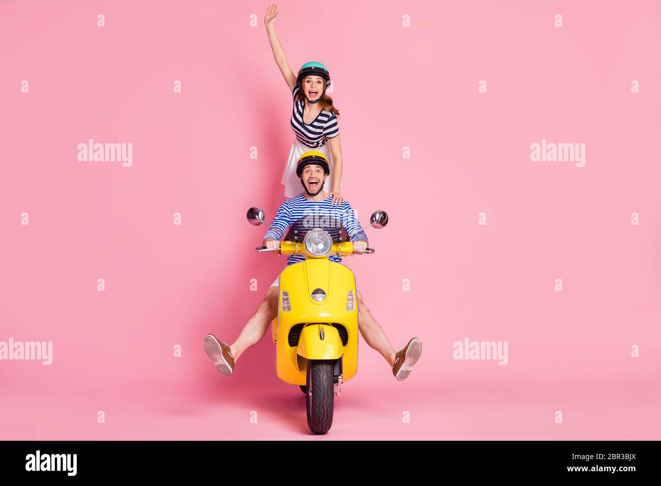 Retrato de agradable atractivo alegre juguetón descuidado loco amigos amigos conducción de amistad ciclomotor sin piernas chica de pie engañar divertirse Foto de stock