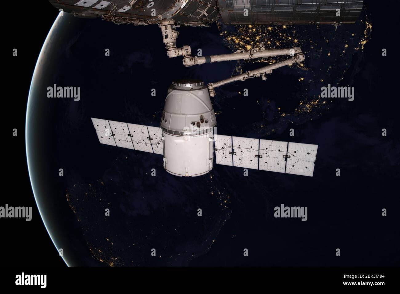 SpaceX Dragon orbitando el planeta Tierra. Los elementos de esta imagen proporcionada por la NASA. Foto de stock