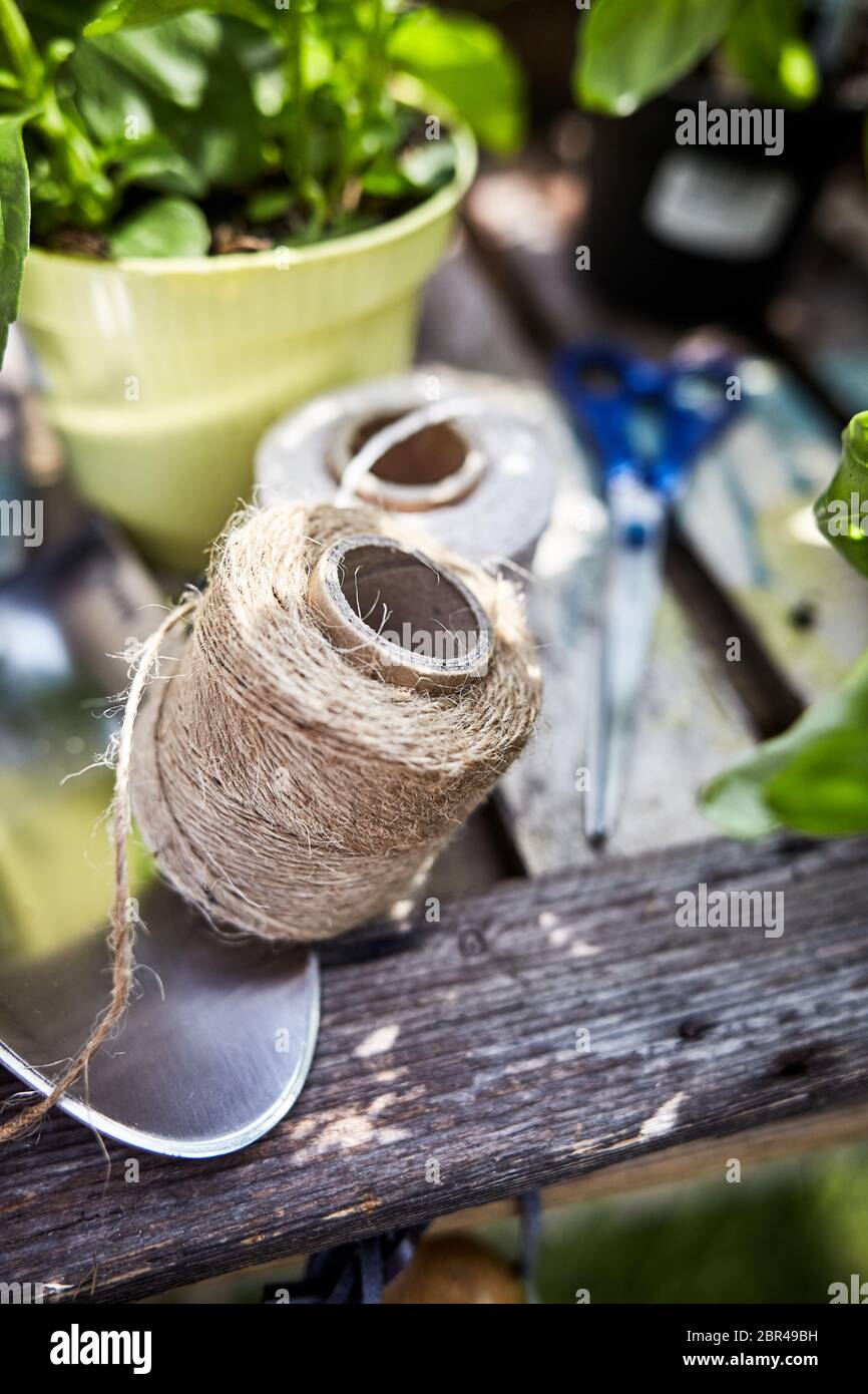 Bola de hilo de cáñamo natural sobre una mesa de jardín con una paleta y  macetas con hierbas en una vista conceptual del muelle y la jardinería  Fotografía de stock - Alamy