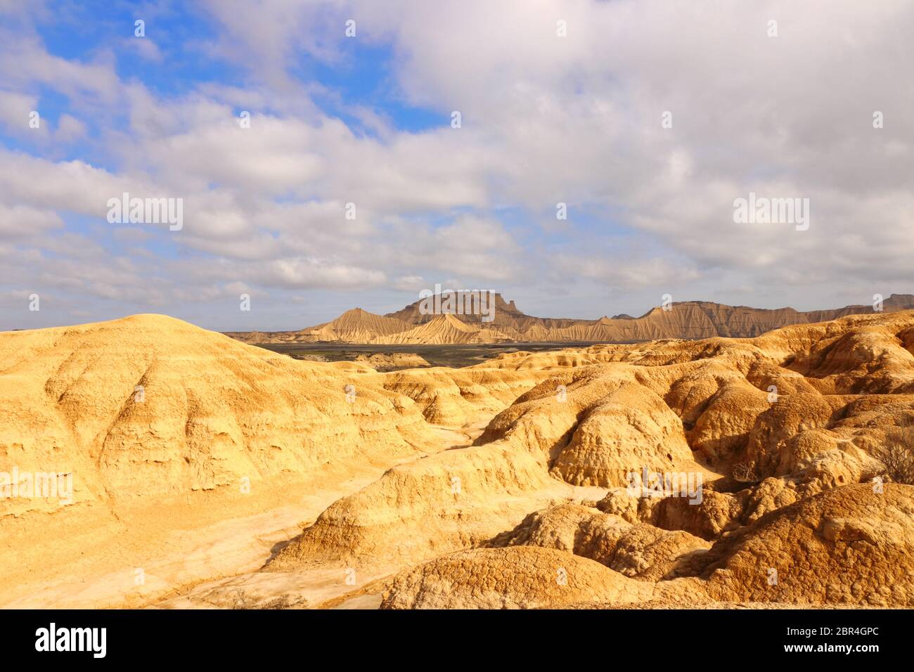 Vista panorámica hacia las fascinantes formas de tierra de Pisquerra y elementos erosionales en primer plano en la región natural semi-desértica Bardenas reales Foto de stock
