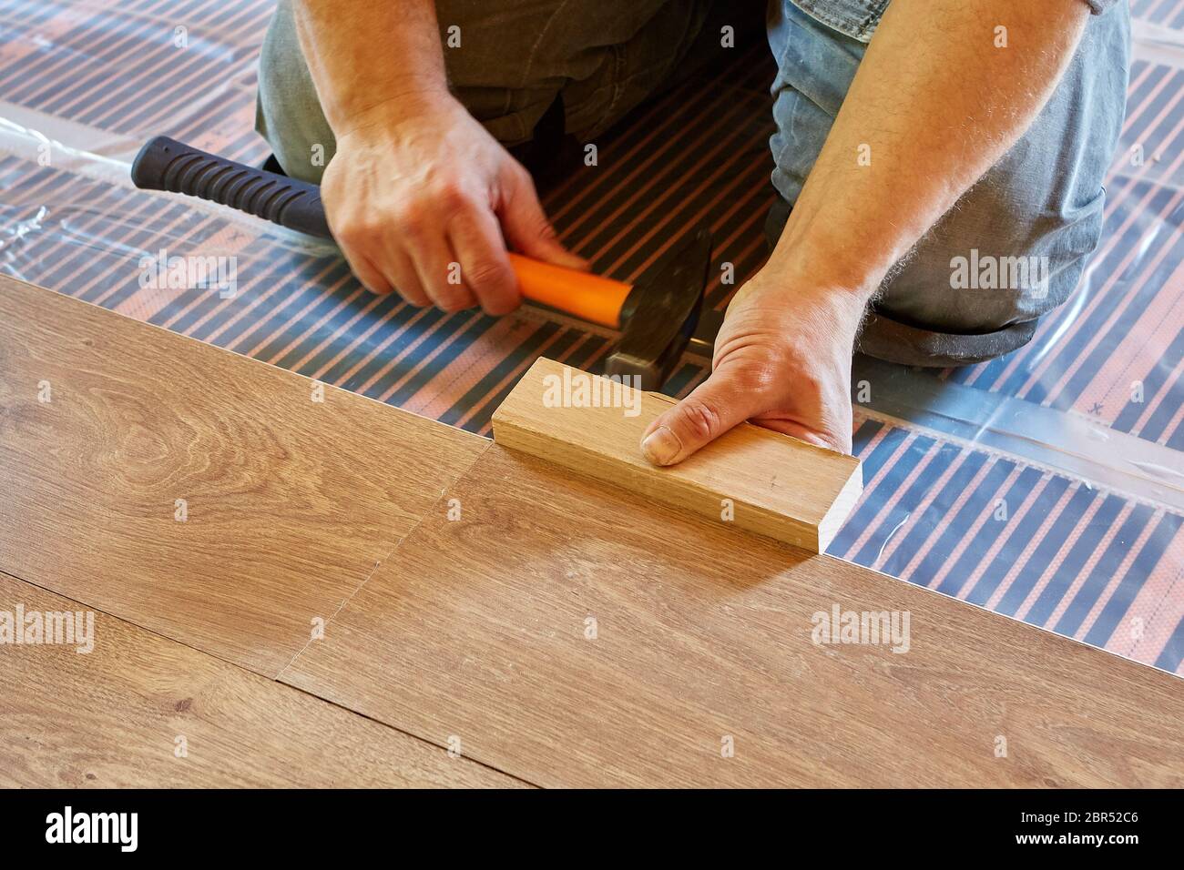 Pisos laminados. El reparador masculino está poniendo el panel de suelo  laminado en un suelo térmico. Sistema eléctrico de calefacción de suelo,  calefacción radiante, inf Fotografía de stock - Alamy