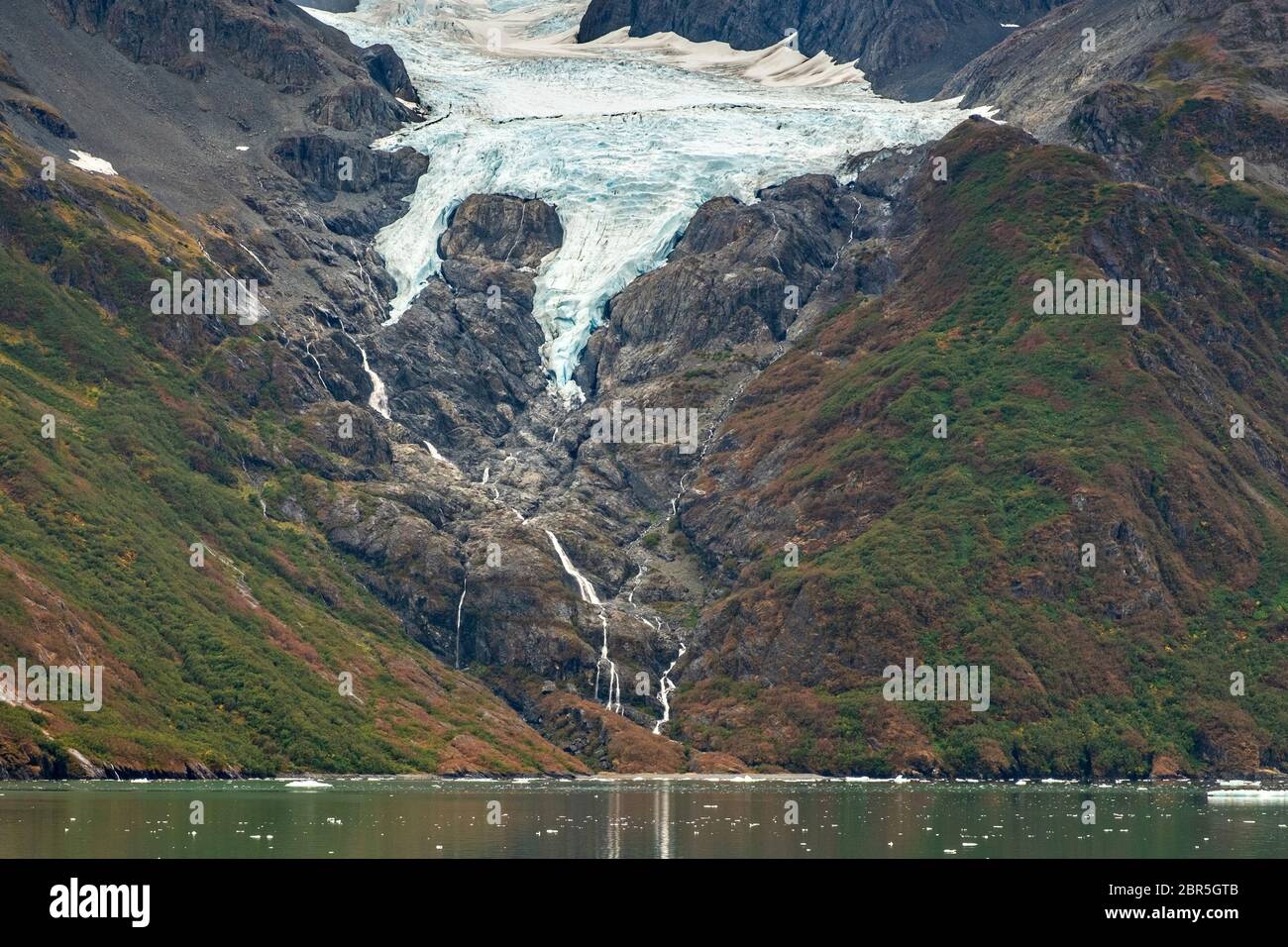 Derrita las cascadas de agua por el Monte Gilbert desde el Glaciar Serpentine en Barry Arm en el fiordo Harriman, cerca de Whittier, Alaska. El glaciar se ha retredado dramáticamente de un glaciar de aguas residuales a convertirse en un glaciar colgante. Foto de stock