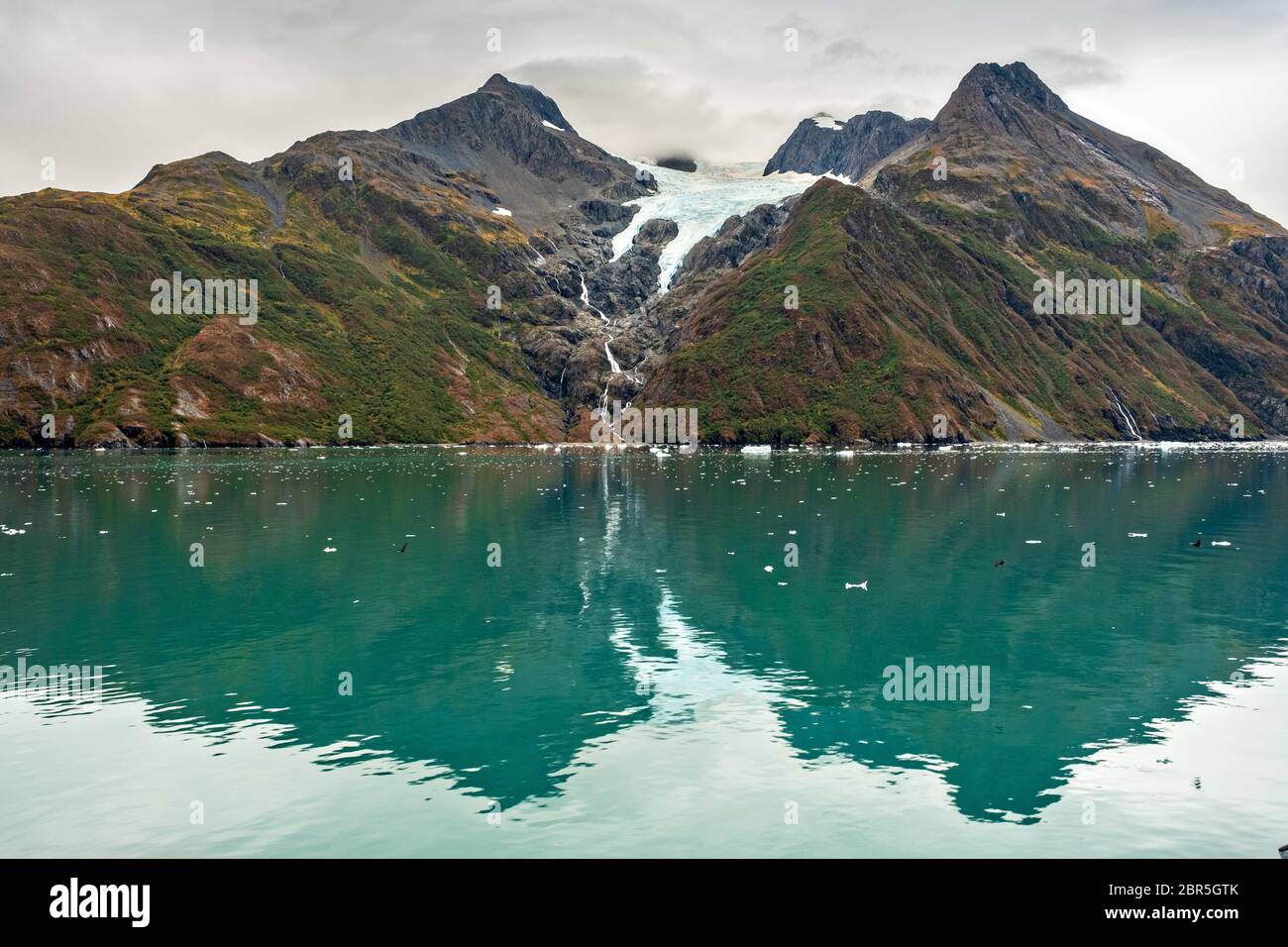 Derrita las cascadas de agua por el Monte Gilbert desde el Glaciar Serpentine en Barry Arm en el fiordo Harriman, cerca de Whittier, Alaska. El glaciar se ha retredado dramáticamente de un glaciar de aguas residuales a convertirse en un glaciar colgante. Foto de stock