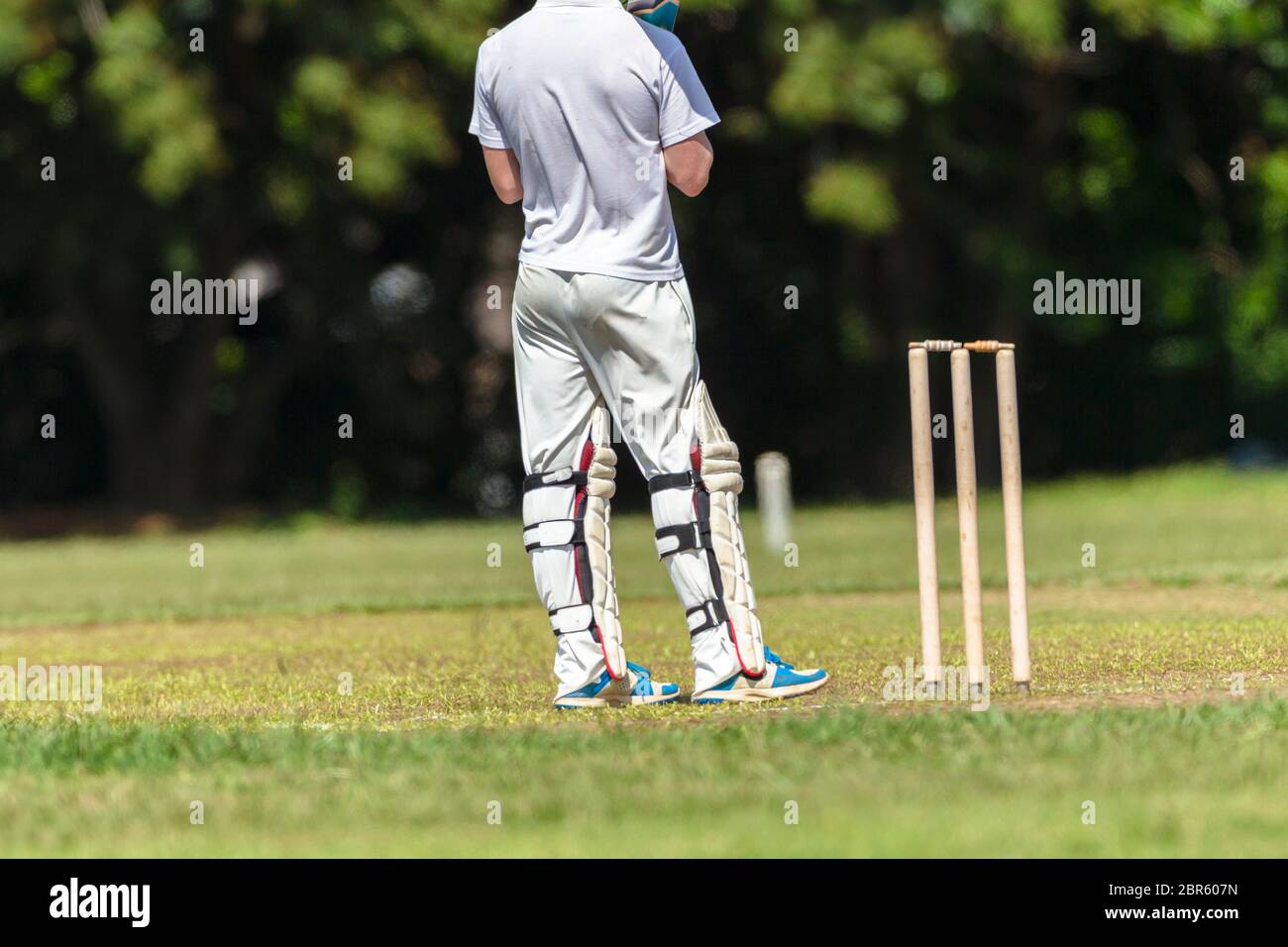 Juego de cricket jugador de primer plano bateando pelota golpe acción de golpe equipos de la escuela secundaria. Foto de stock