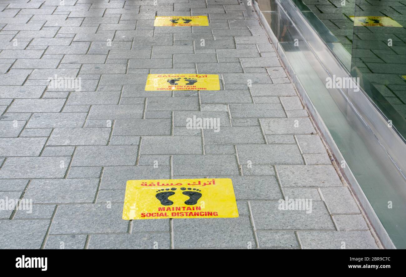 Mantener pegatinas de distanciamiento social pegadas en el piso frente al restaurante en Qatar Foto de stock