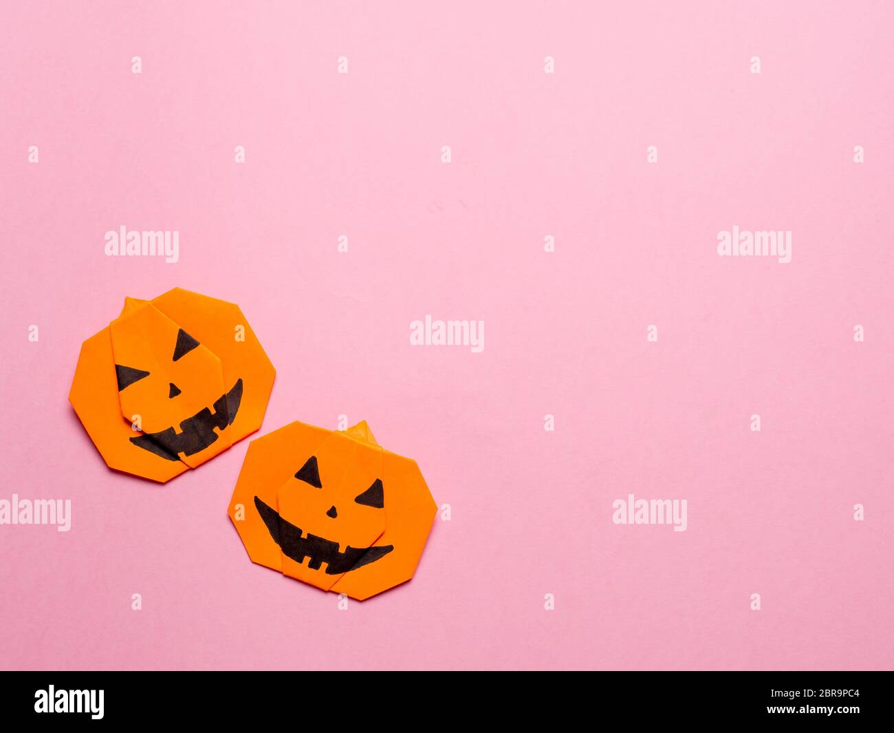 Concepto de Halloween. Calabaza de origami de papel sobre fondo rosa. Idea  simple para halloween - fácil de hacer calabazas de papel en el color de  moda Ceilán amarillo backgr Fotografía de