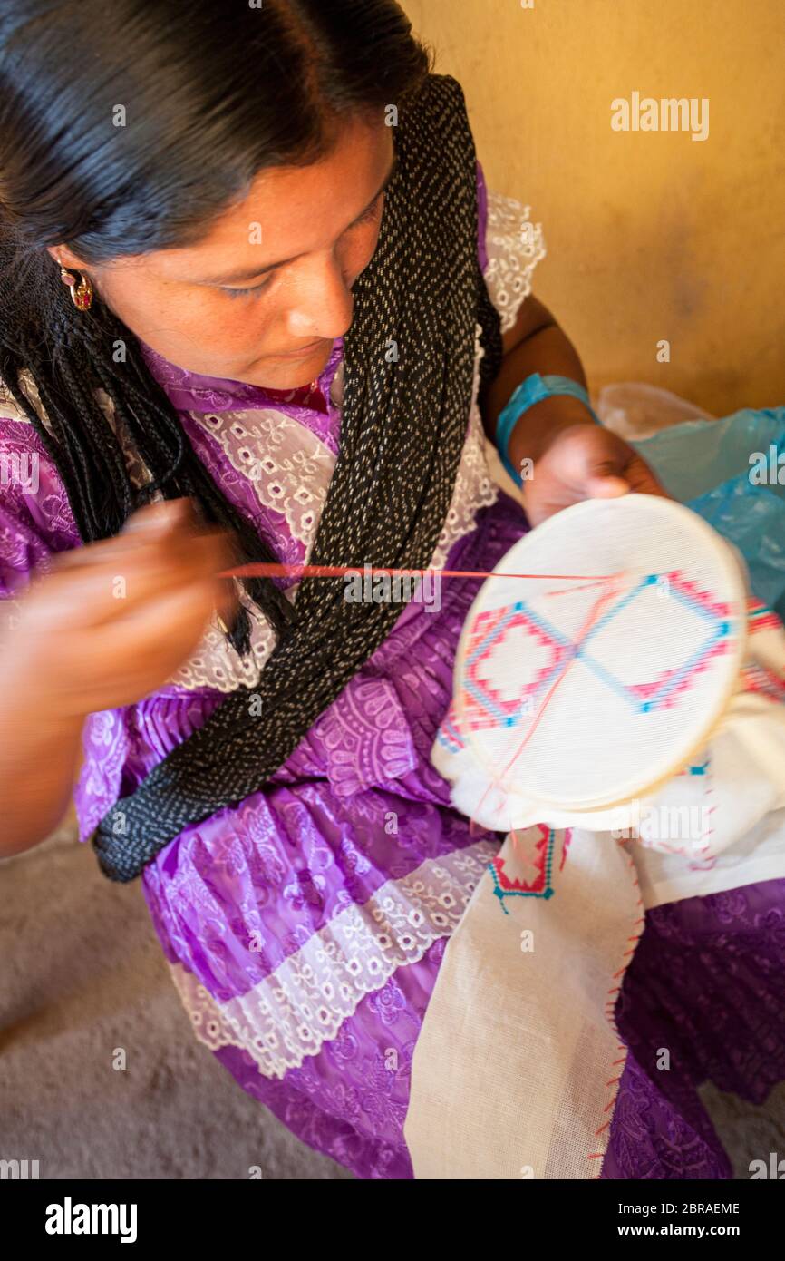 Una artesana femenina cruza un diseño para una blusa tradicional en San Vicente Coatlan, Oaxaca, México. Foto de stock