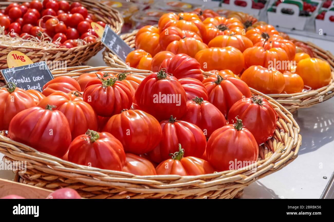 Tomates jugosos rojos y naranjas en un puesto de mercado en Gordes, Provenza, Francia Foto de stock