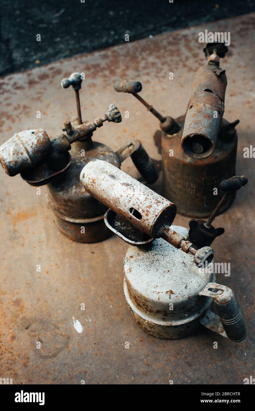 La antorcha de gas oxidada vieja se pone sobre una hoja de hierro oxidada. Chatarra. Primer plano. Foto de stock