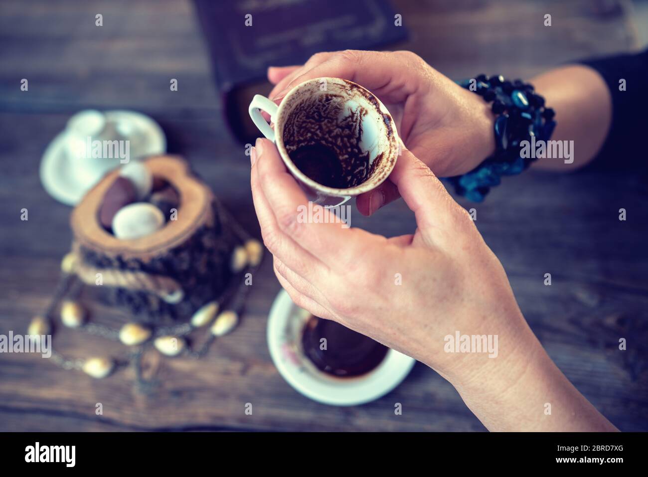 la mujer sostiene la taza y cuenta la fortuna con una taza de café tradicional turco Foto de stock