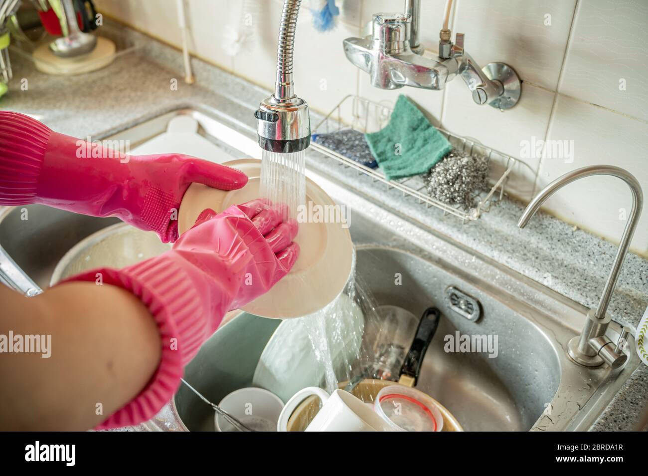 Hombre de mediana edad lavando las manos en el fregadero después de la comida. Foto de stock