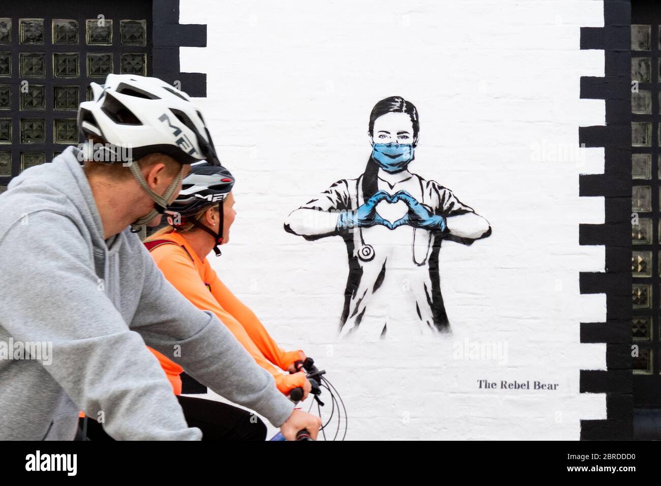 El ciclista pasa el graffiti en Glasgow mostrando aprecio por el NHS y las enfermeras durante el bloqueo de la pandemia de coronavirus, Glasgow, Escocia, Reino Unido Foto de stock