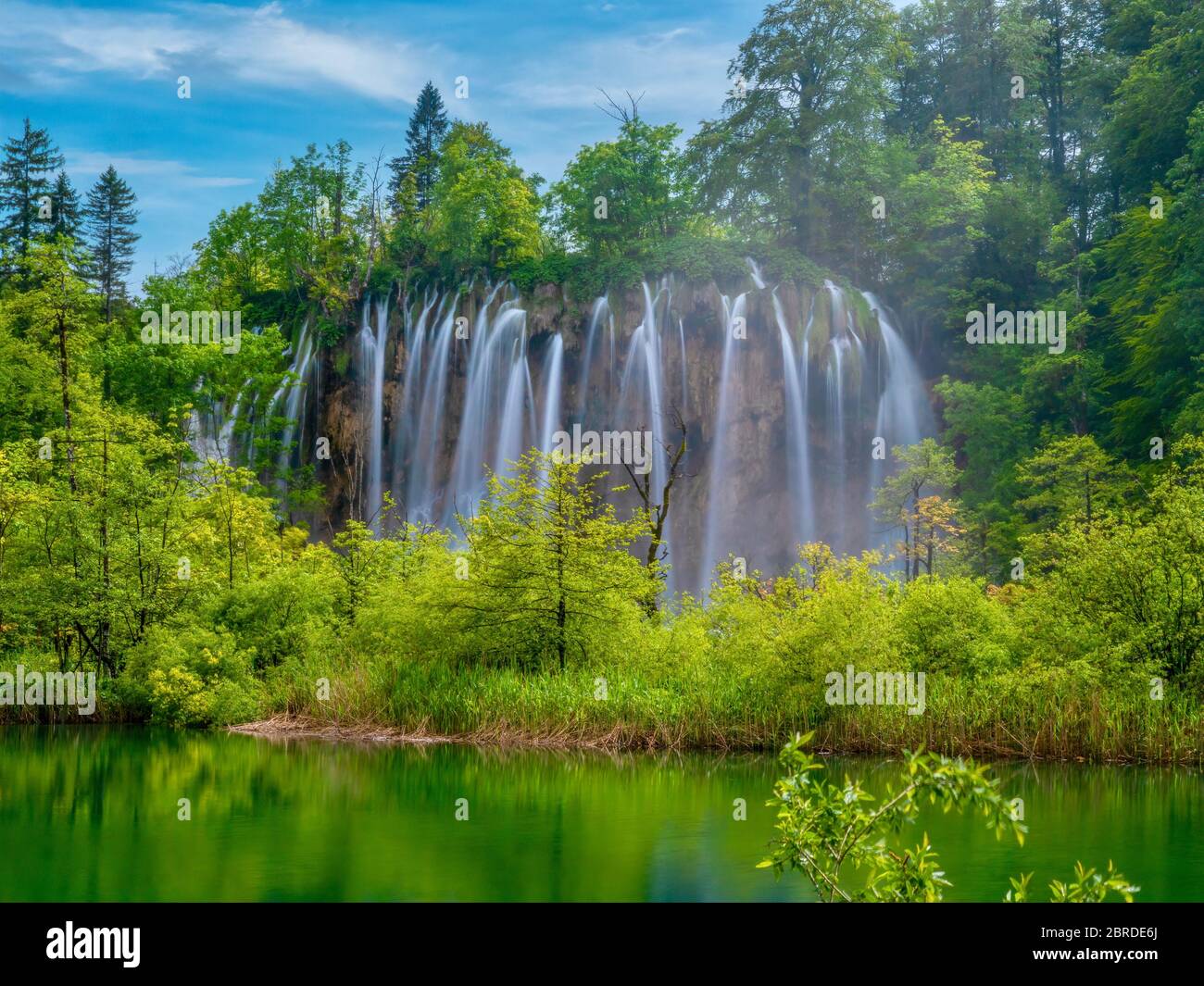 Larga exposición de un hermoso conjunto de cascadas en el vibrante bosque verde del Parque Nacional de los Lagos de Plitvice, Croacia. Foto de stock