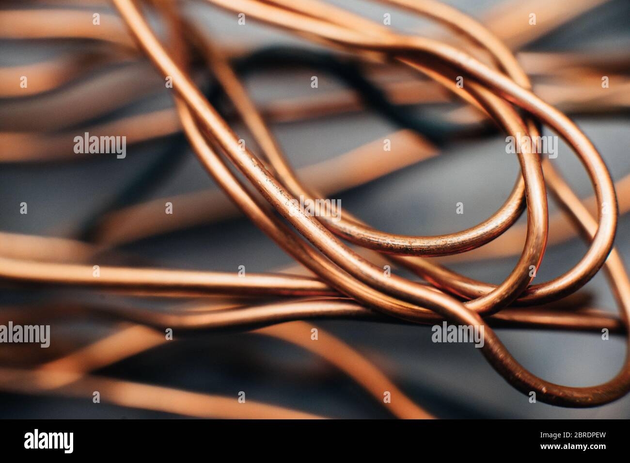 Chatarra de cobre, alambre, bobinados de motores y transformadores, alambre eléctrico sin aislamiento. Sobre el fondo de una lámina de cobre. Primer plano. Foto de stock