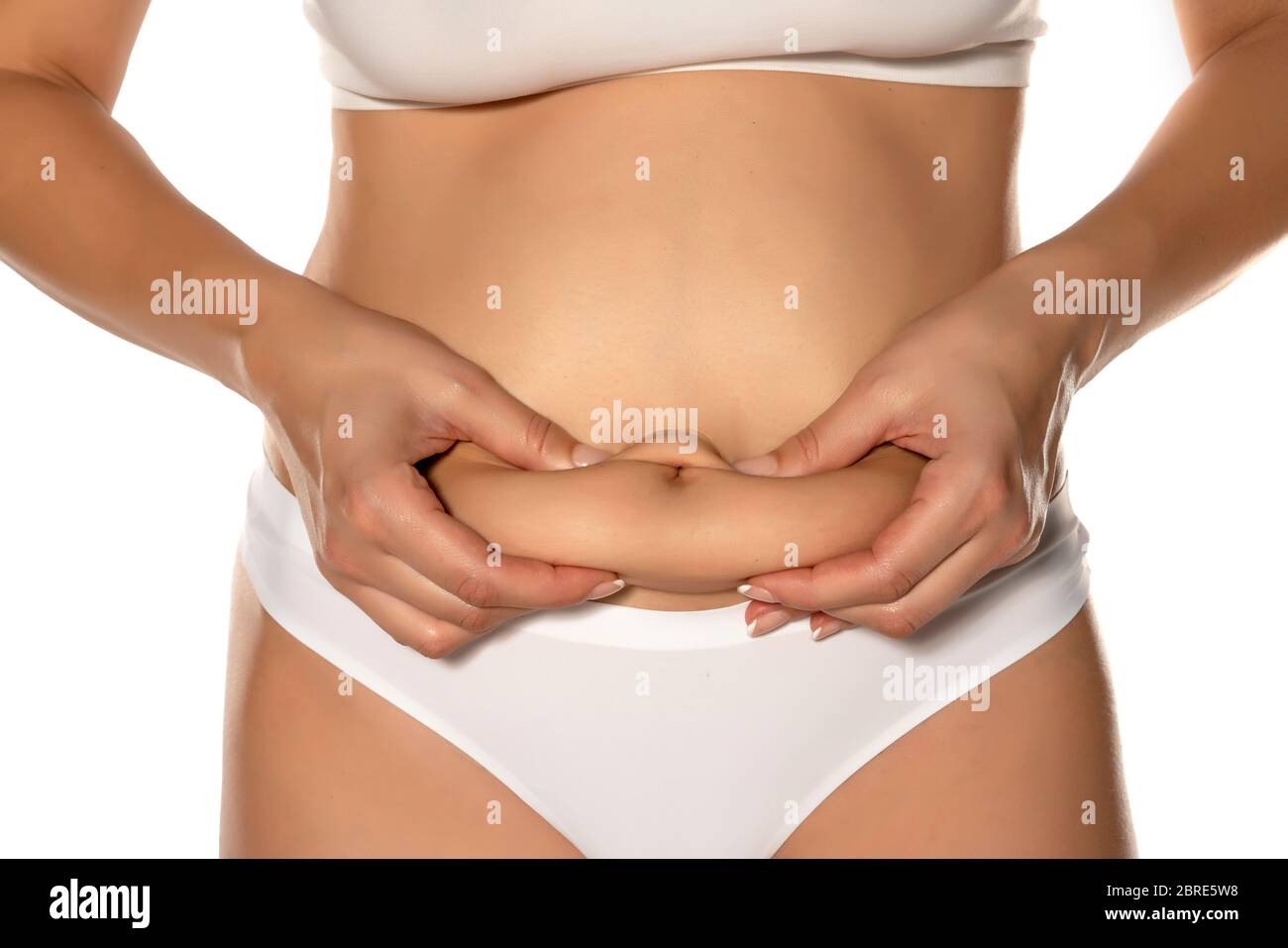 mujer apretando su vientre gordo sobre fondo blanco Foto de stock