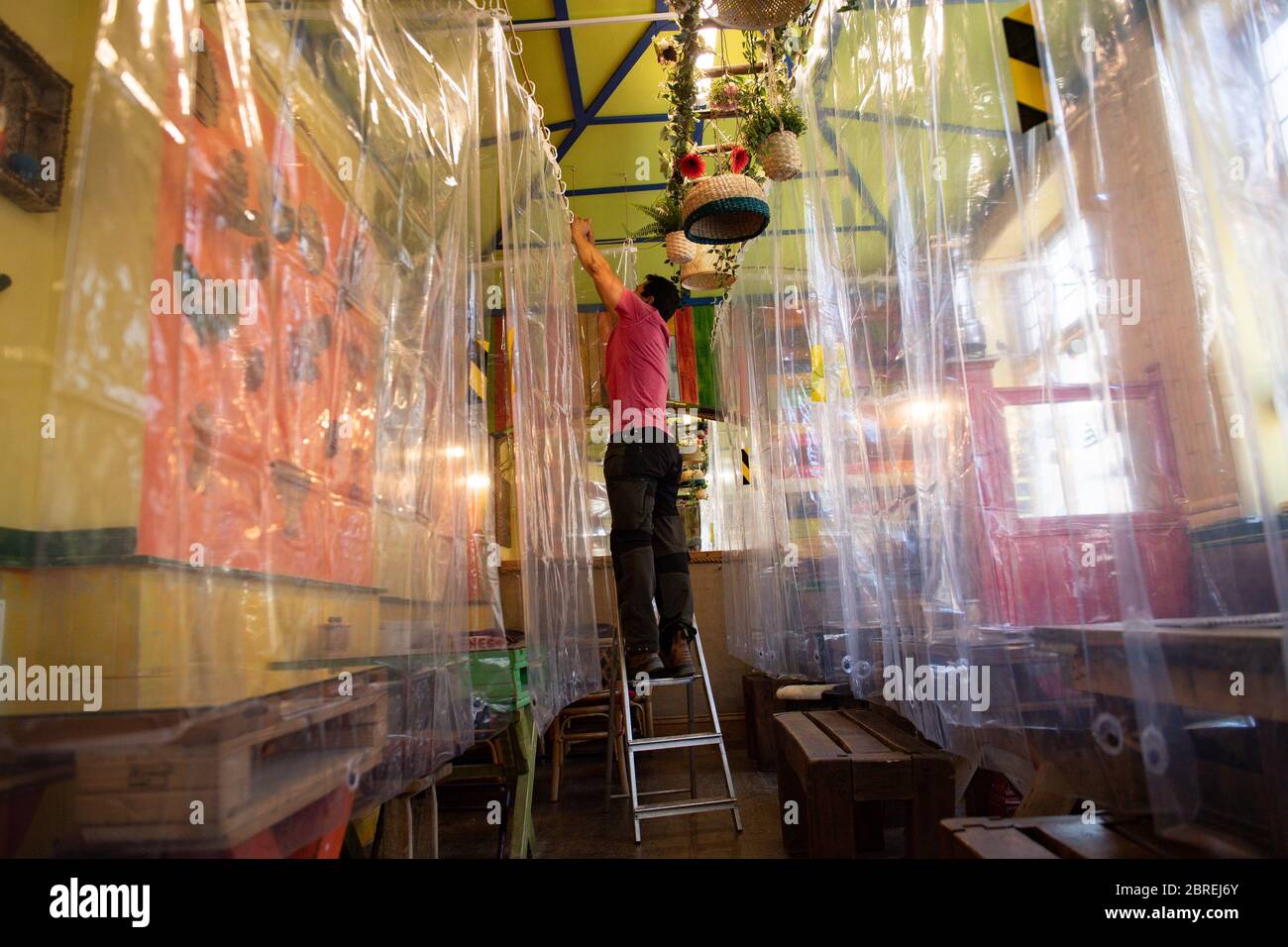 Francini Osorio, propietario de un café, que ha instalado un purificador de aire y 35 cortinas de ducha claras, que dividirán a los clientes y las mesas, en el Café Francini de Colombia, Worcester, listo para la reapertura de su negocio como restricciones de cierre se alivian. Foto de stock