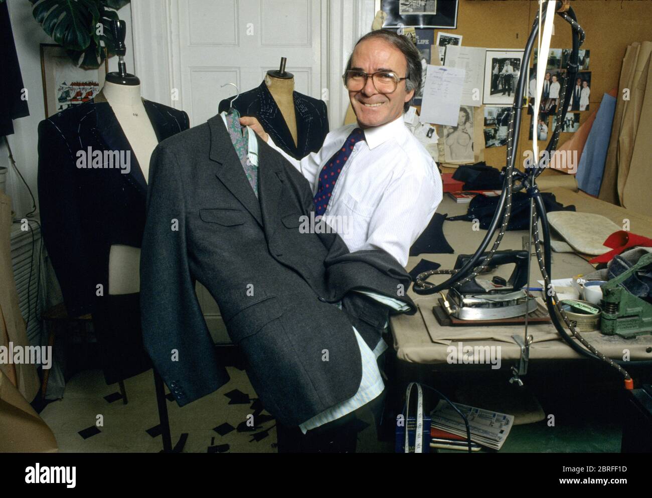 Royal warrant dresswaker to HM Queen Elizabeth II, Sir Hardy Amies. Pino -  sastre para hombre con traje de 2000 libras para lord Snowdon en el trabajo  en la sala de exposición