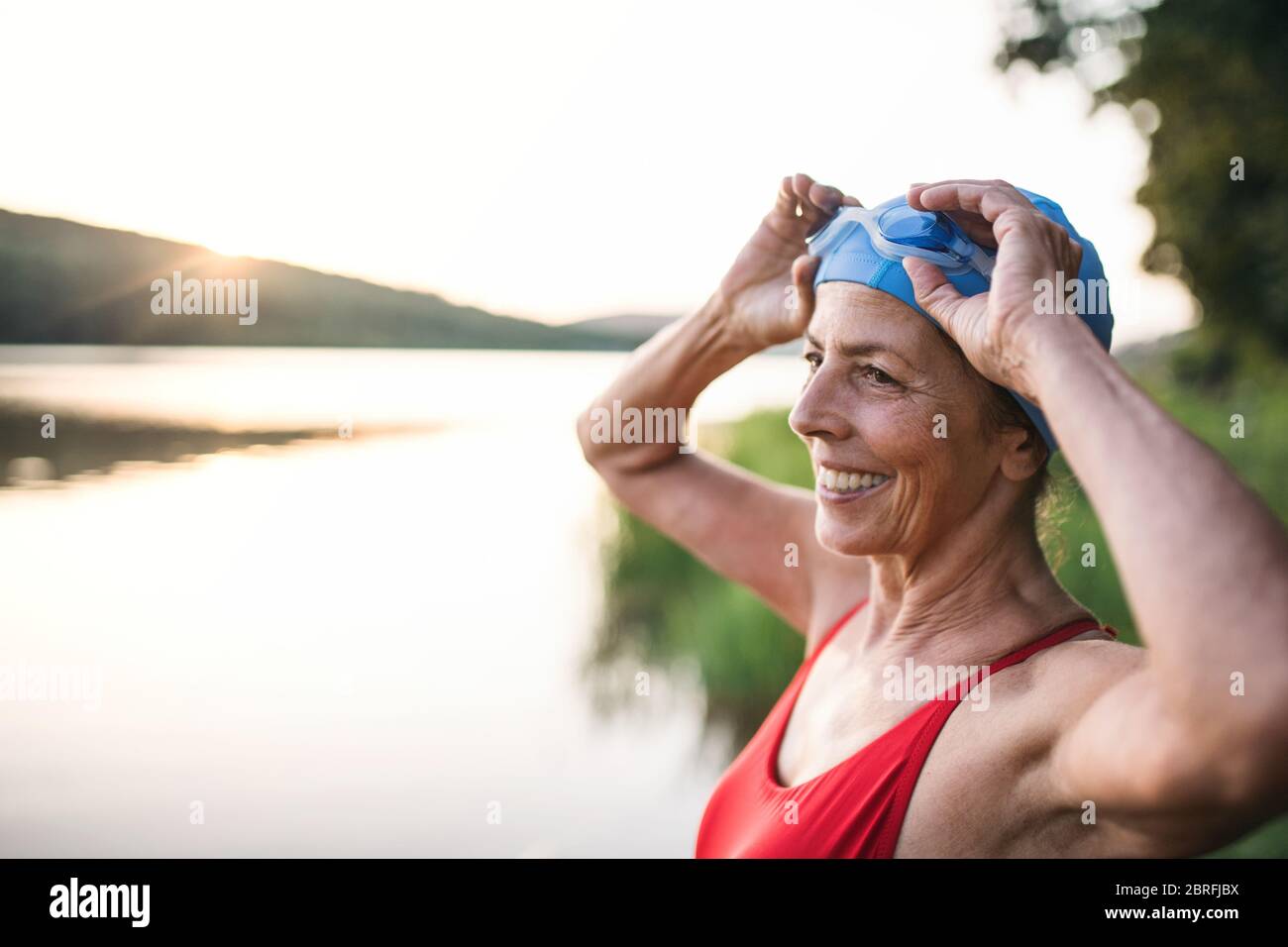 Una mujer senior citizen en traje de baño, gorra y gafas natación goza de  un estilo de vida saludable y permanece joven por la natación Fotografía de  stock - Alamy