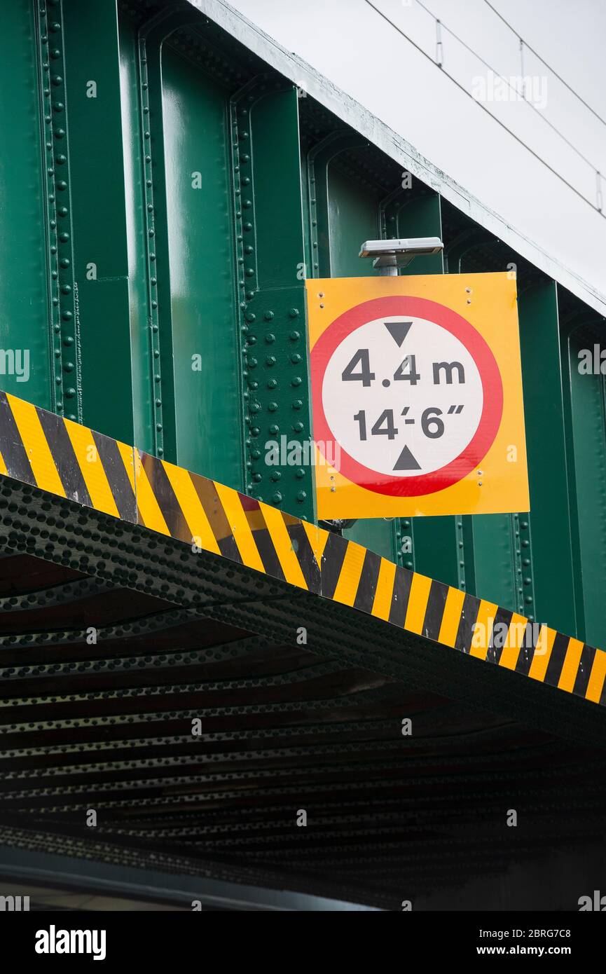 Signo que muestra la restricción de altura en un puente ferroviario en el Reino Unido. Foto de stock