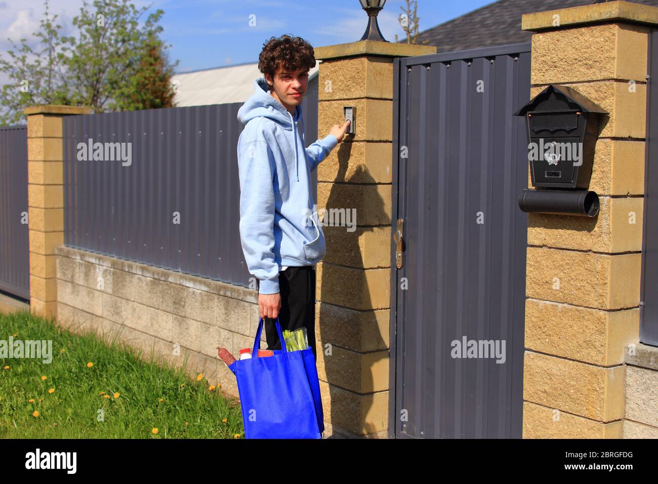 Un chico joven con una bolsa de productos en sus manos. Foto de stock