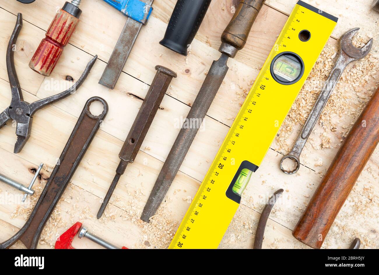 Detalle de un conjunto de herramientas de carpintería colocadas sobre un tablón de madera de pino natural. Concepto de trabajo y bricolaje. Foto de stock