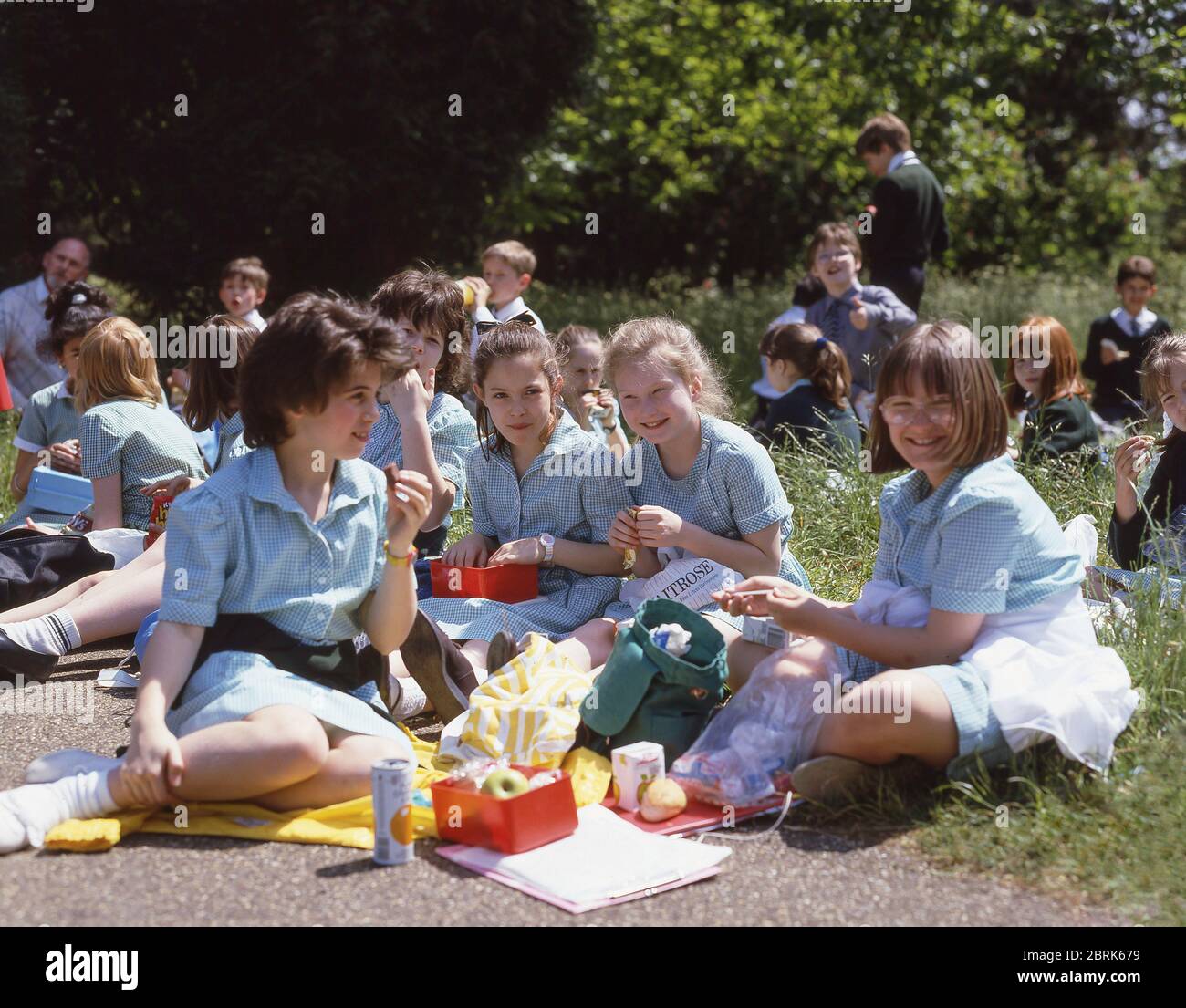 Niños de escuela que tienen almuerzo en el viaje de campo, Surrey, Inglaterra, Reino Unido Foto de stock