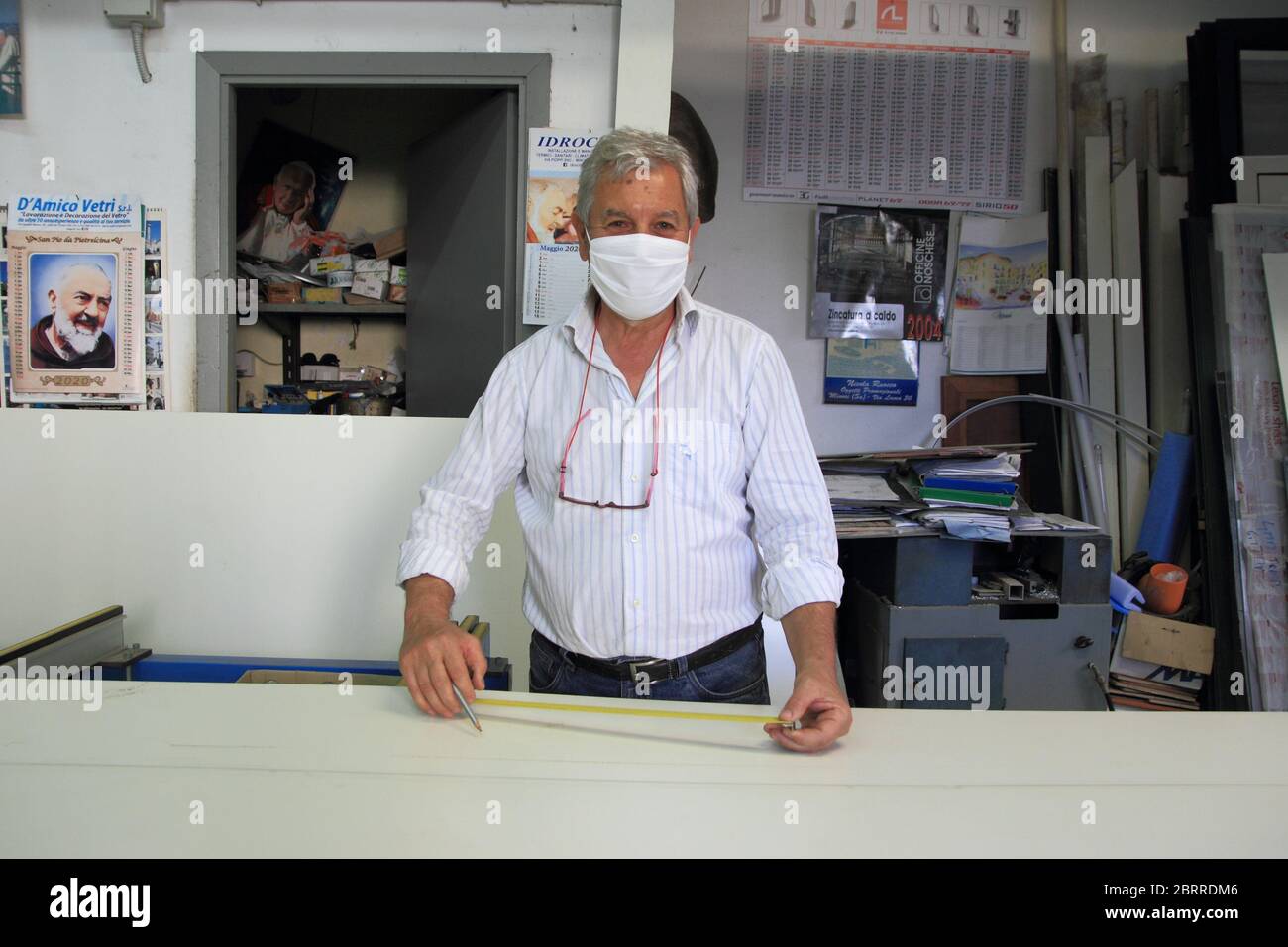 Un artesano de accesorios de aluminio en su taller durante la preparación de una puerta . Máscara para las reglas de la lucha contra la falsificación Foto de stock