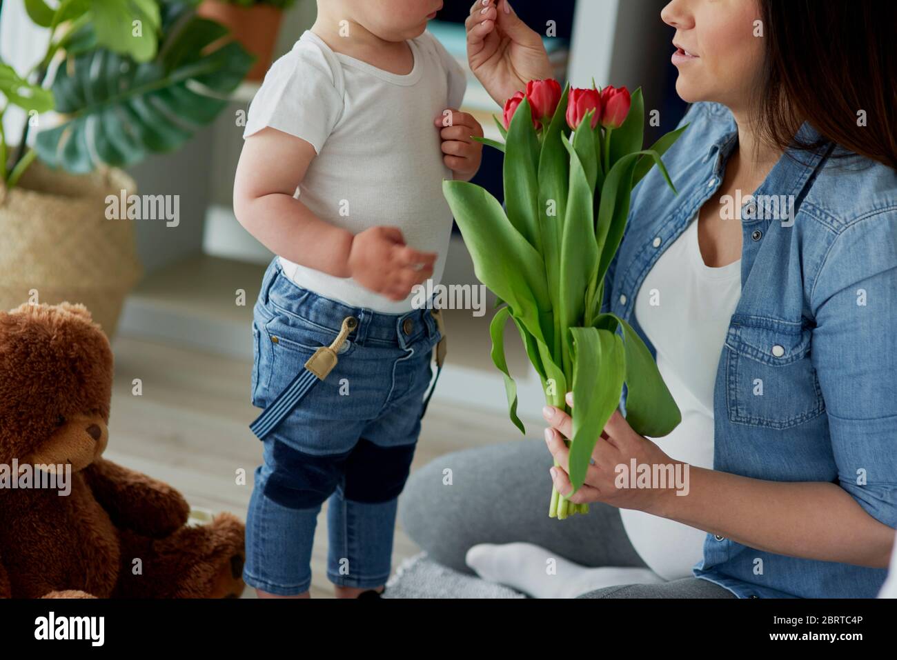 Madre recibiendo flores de su niño pequeño Foto de stock