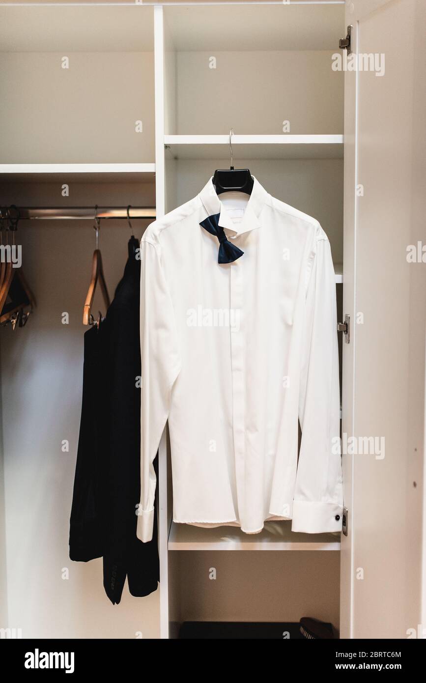 Camisa blanca con lazo colgando en el armario Fotografía de stock - Alamy