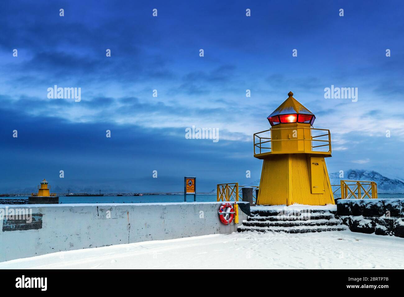 Faro en la entrada del Puerto Viejo, Reykjavik, Islandia. Hora azul al  amanecer durante el invierno, con balizas amarillas y nieve en el suelo  Fotografía de stock - Alamy