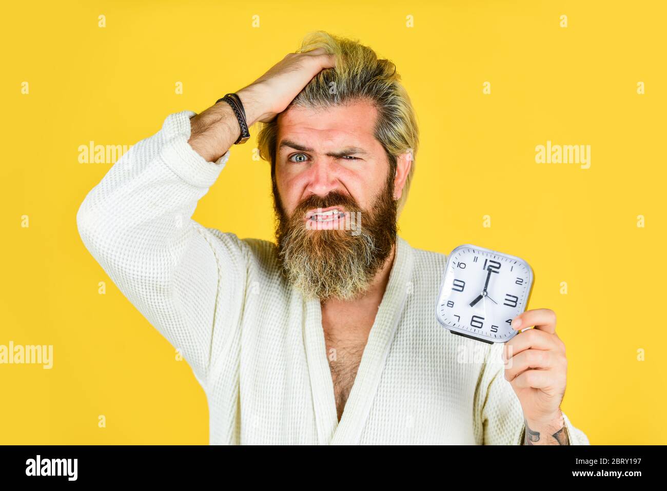 Demasiado temprano. Dolor de cabeza a la hora de acostarse. Destruye el  reloj. Hombre enojado guapo dentro despertar apague el reloj despertador.  El hombre cansado en el dormitorio no está feliz. Sufre