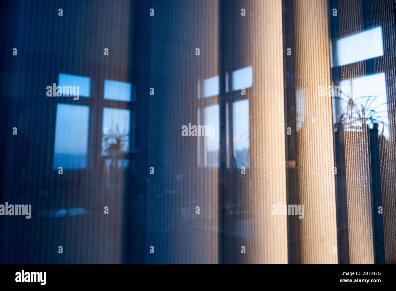 Persianas verticales anchas fuera de la ventana a la luz de la puesta de  sol, un reflejo de las ventanas de oficina Fotografía de stock - Alamy