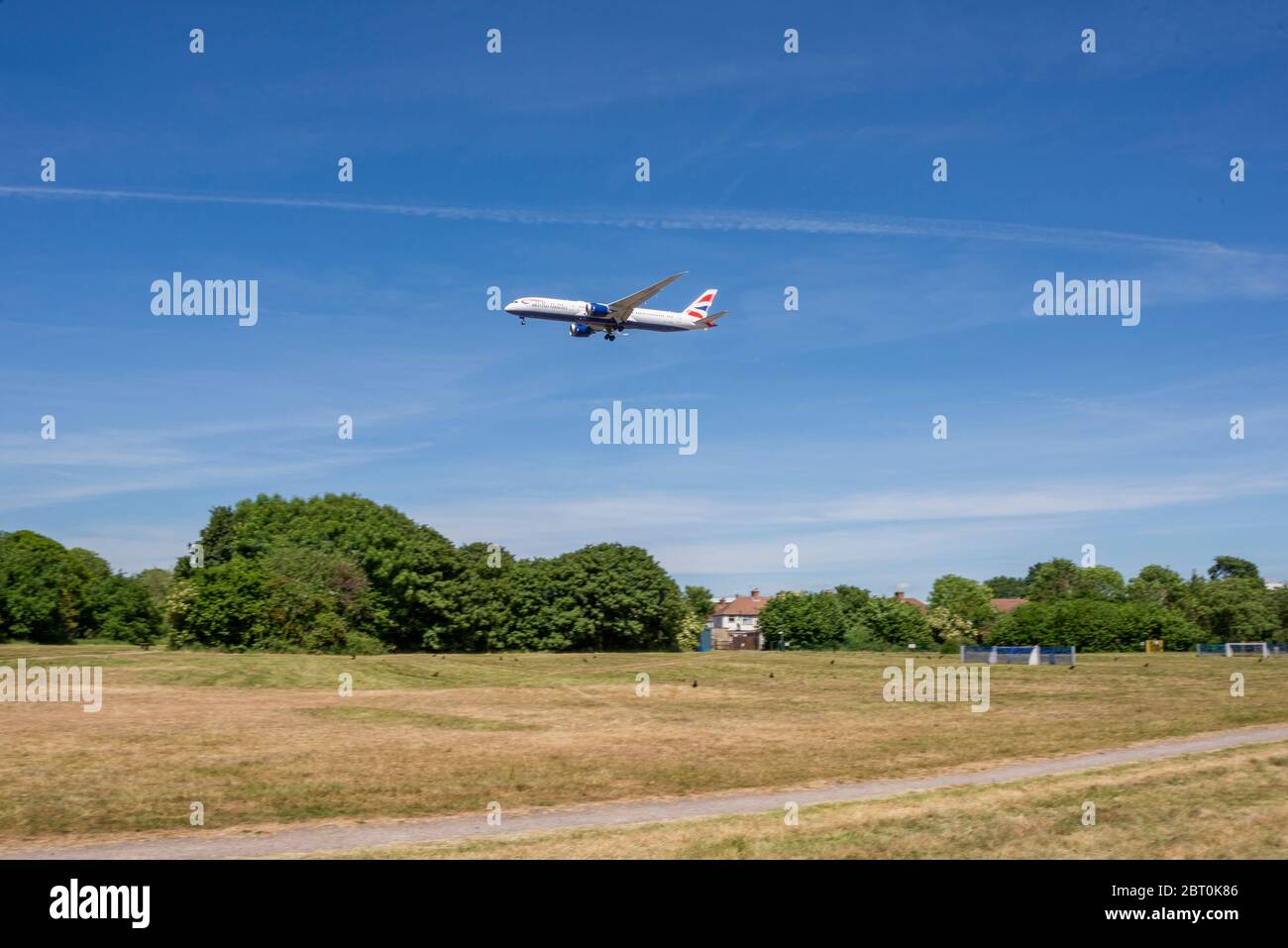 Avión de avión de avión de British Airways en aproximación a la tierra sobre un parque espacial verde en Cranford. Avión aterrizando en Londres Heathrow sobre área de juego Foto de stock