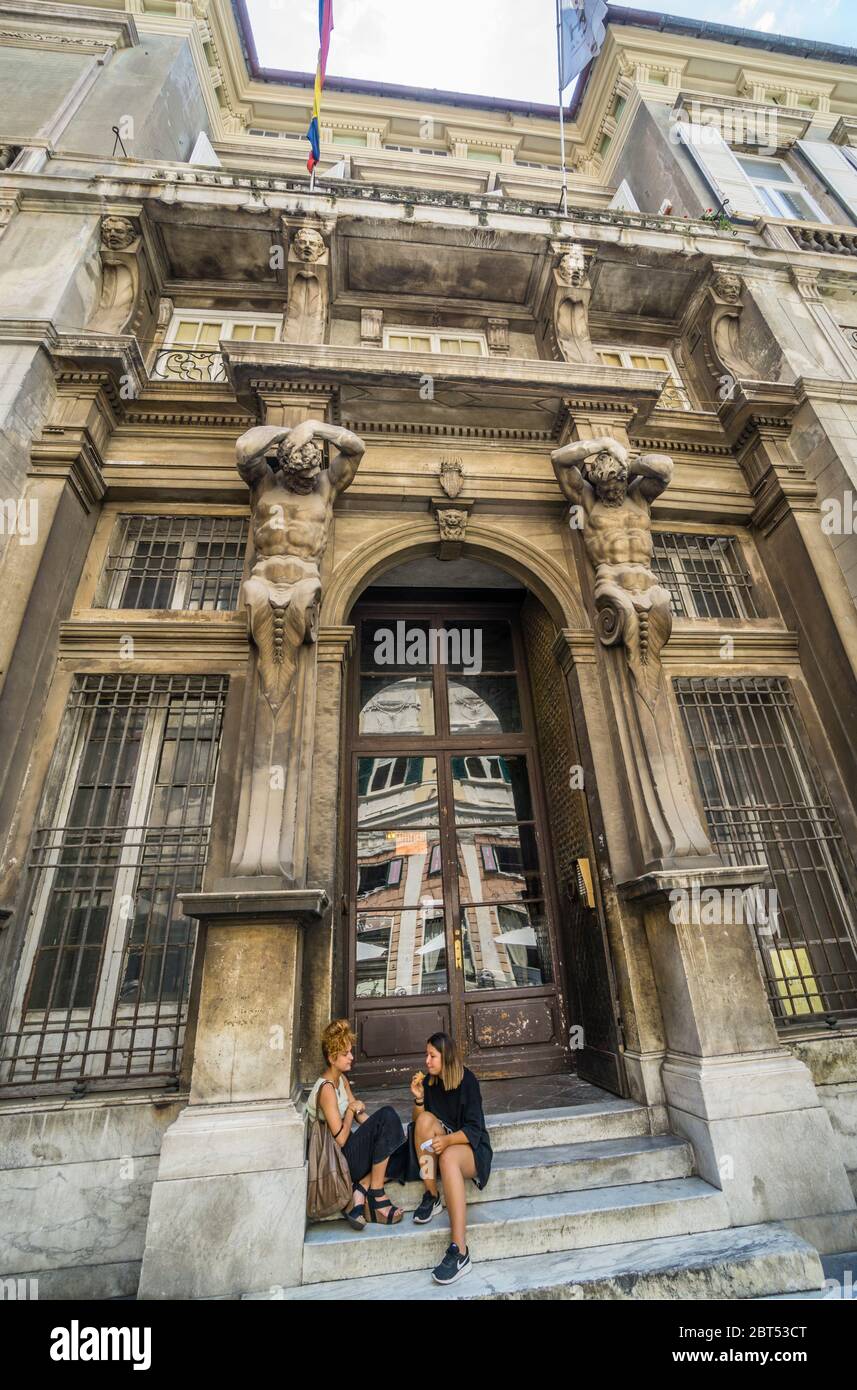 Descanse en los escalones del portal del Palazzo Gio Carlo Brignole, decorado con dos telamones, Via Giuseppe Garibaldi en el centro histórico de la ciudad de Geno Foto de stock