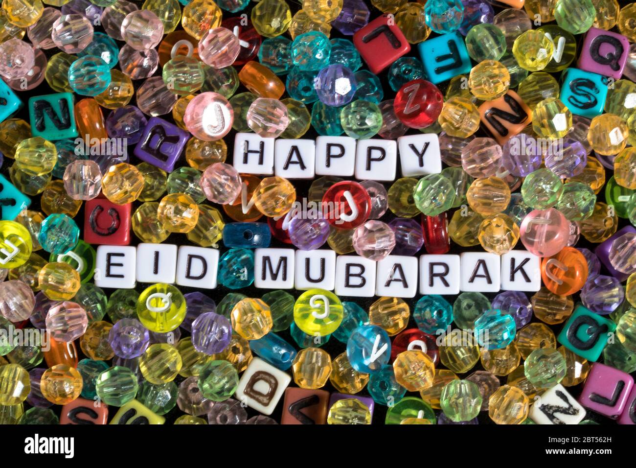 Frase de Mubarrak Eid feliz rodeada de cuentas y bloques del alfabeto Foto de stock