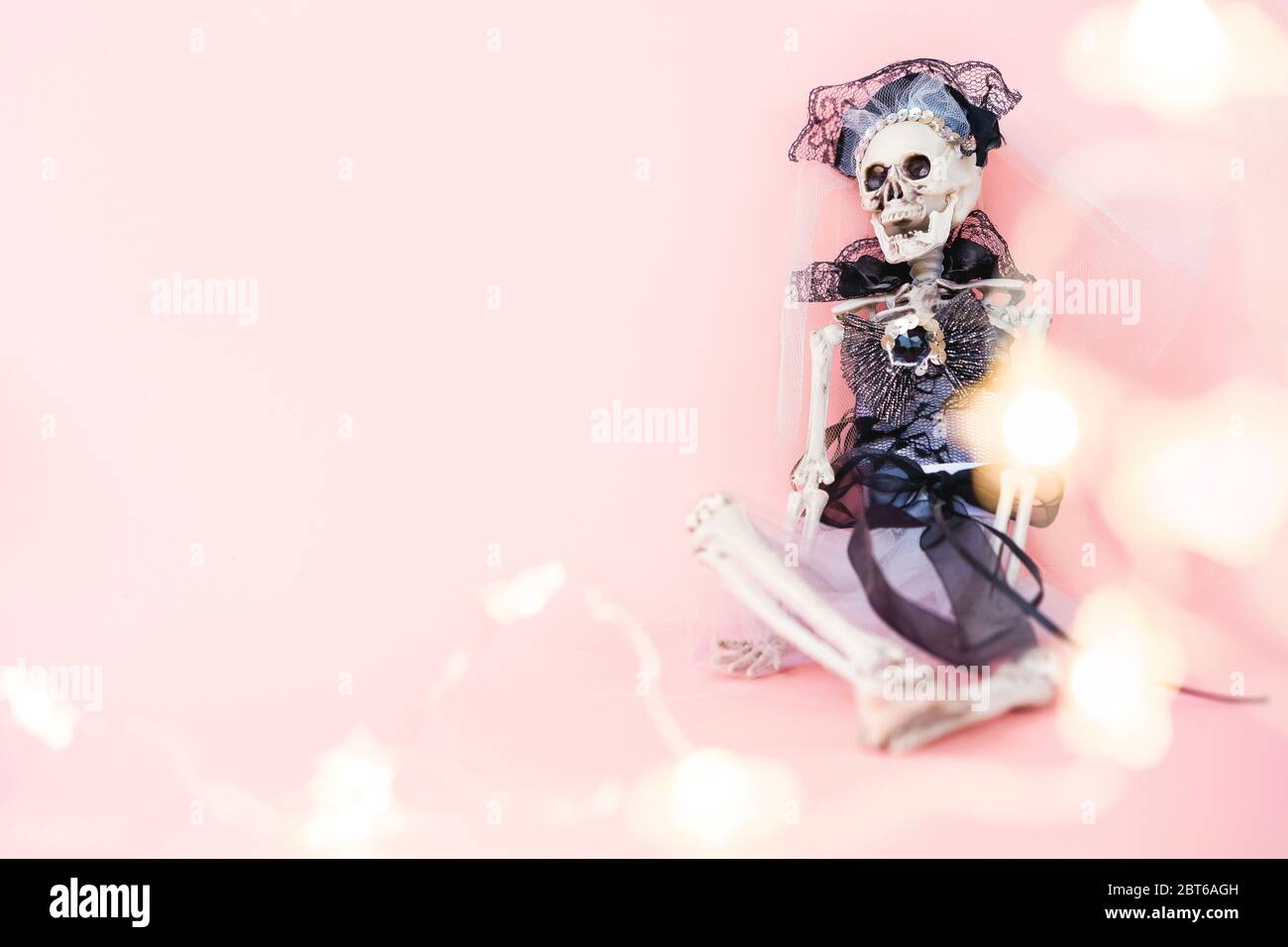 El esqueleto de la novia vestido de novia sentada contra la pared Foto de stock