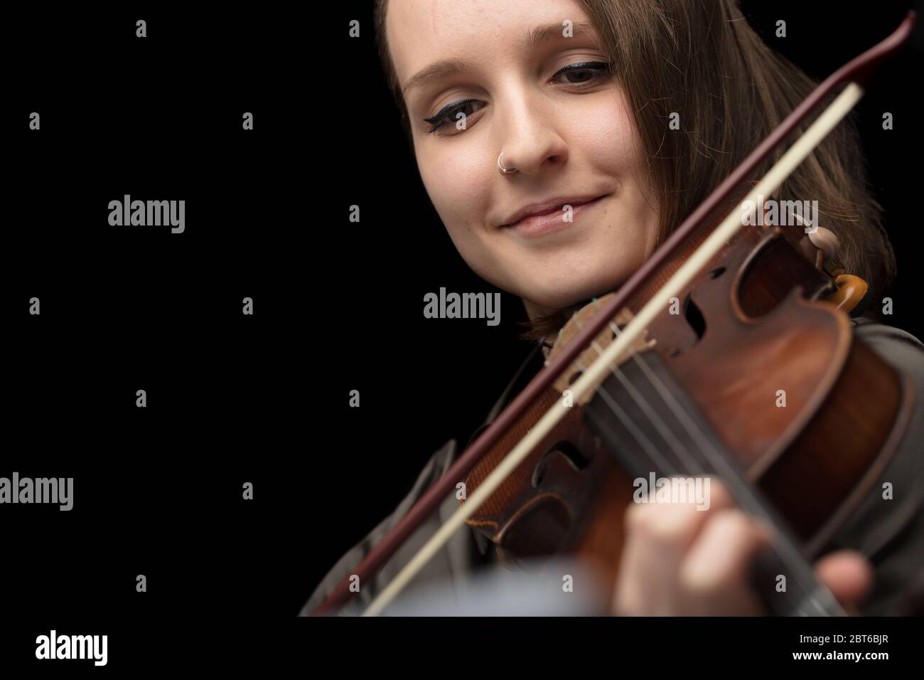 Feliz mujer sonriente tocando un violín barroco durante un ensayo o actuación clásica en vivo disfrutando de su pasión por el instrumento en un primer plano cr Foto de stock