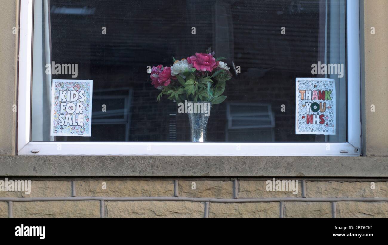 Una ventana en una casa con terraza con "niños en venta" y "NHS / trabajador clave arco iris gracias" signos durante la pandemia de Coronavirus (COVID-19). Foto de stock