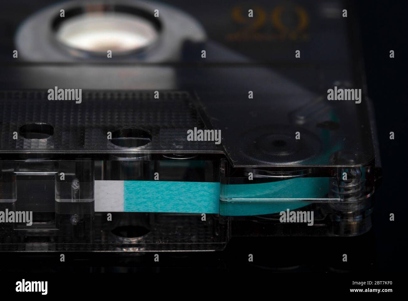 Cabezal de cinta que abre cerca de la cinta de casete de audio y el extremo de la cinta magnética verde Foto de stock