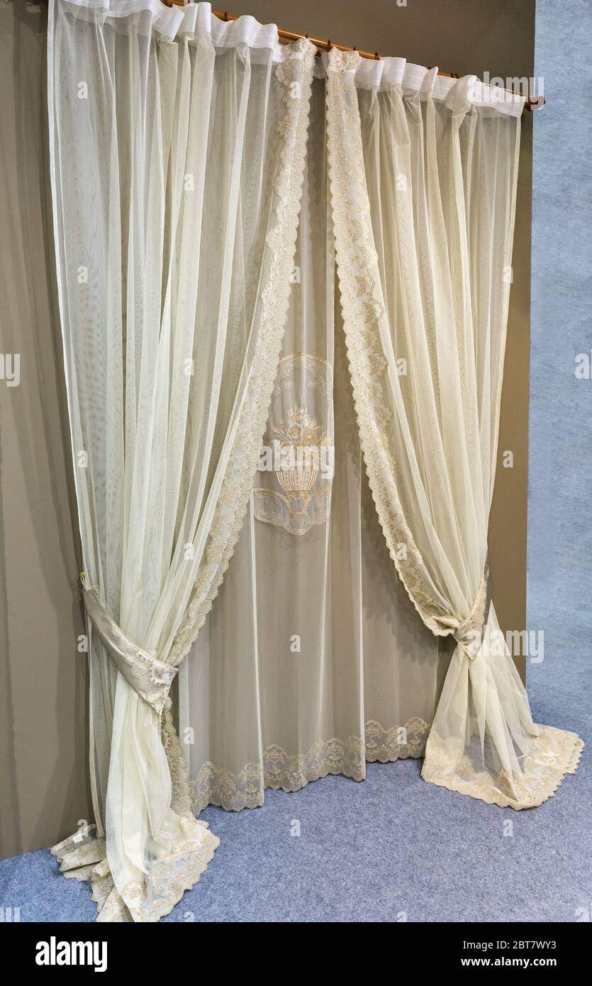 Cortinas de tela densa con ornamentos, lambrequin, pelmet, jabot, y tul con bordado. Decoración del interior del salón en la sala de estar Foto de stock